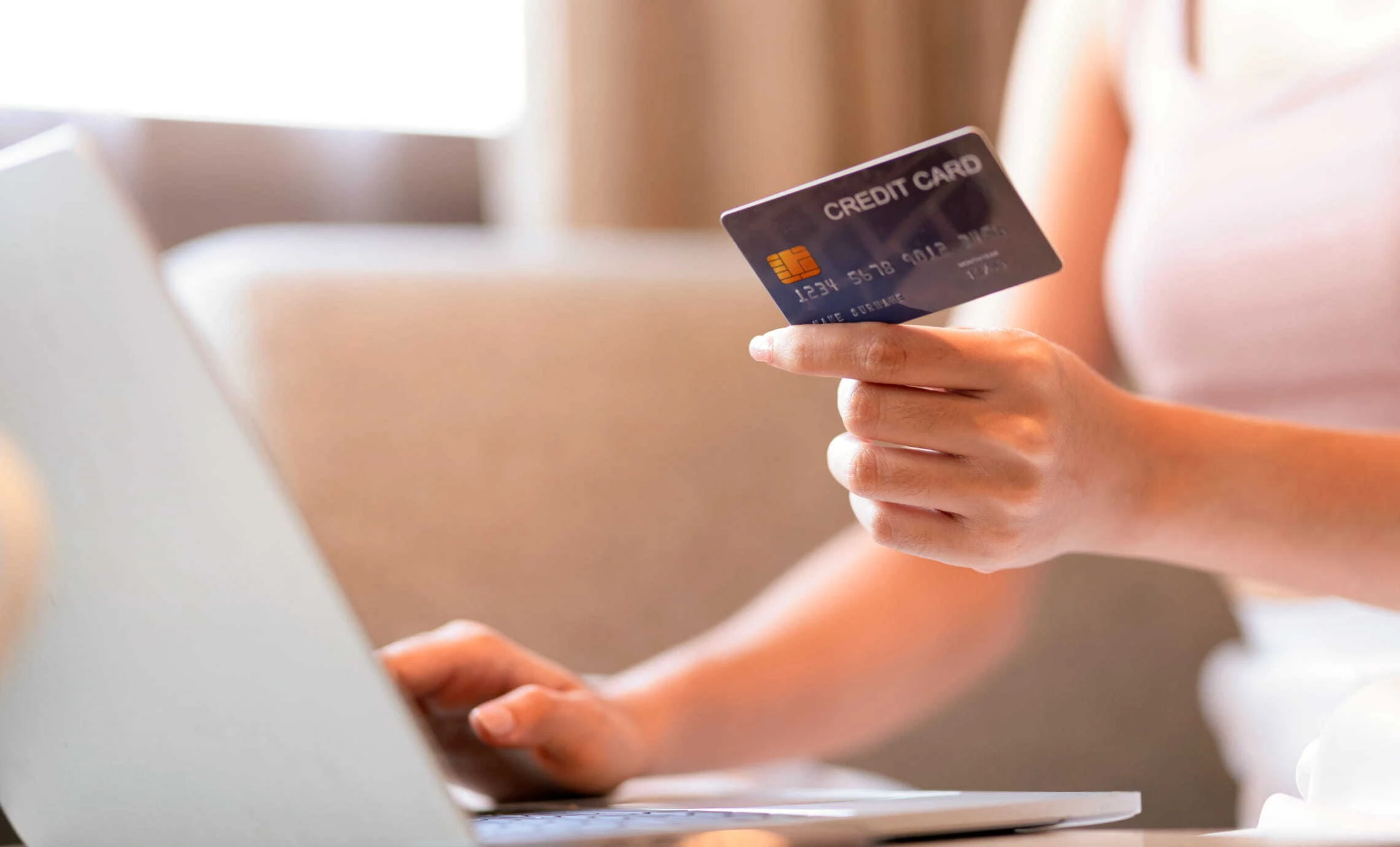 An image of a person entering their credit card details into a laptop