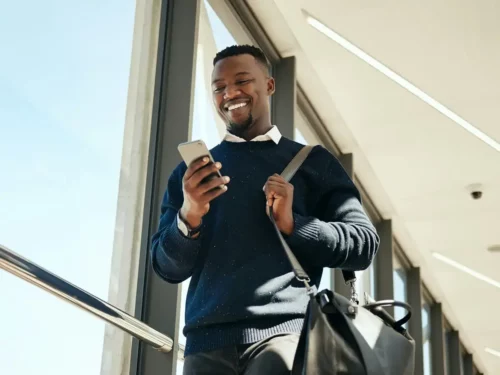 Man walking through airport looking at their smartphone