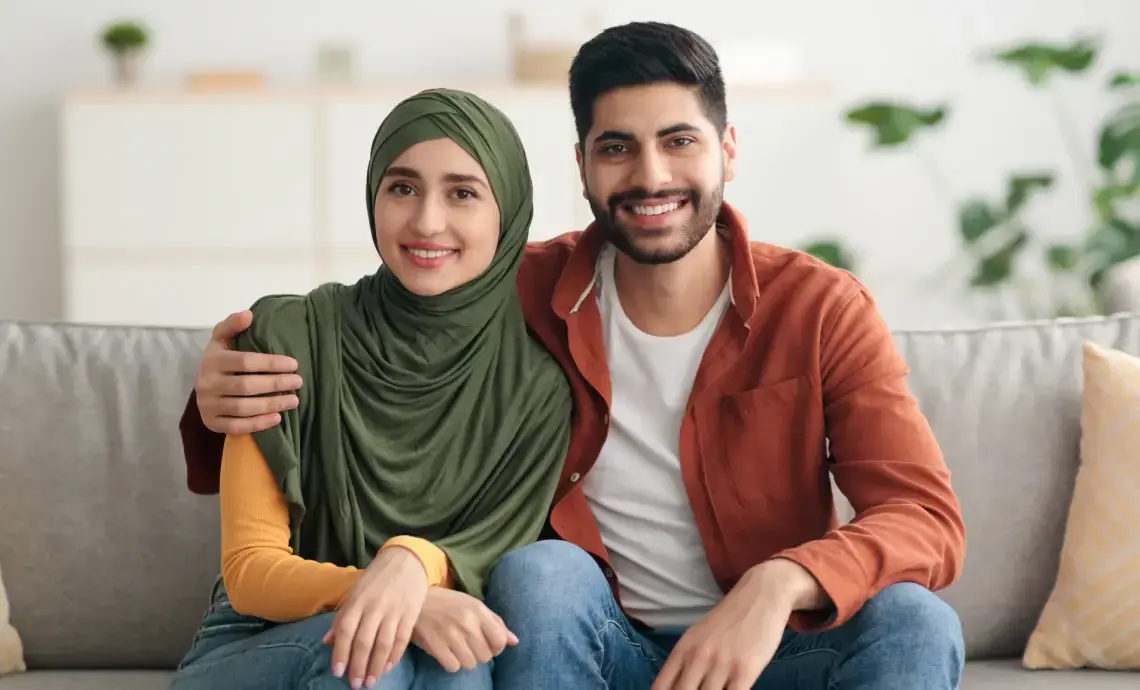 Muslim couple sat together on the sofa