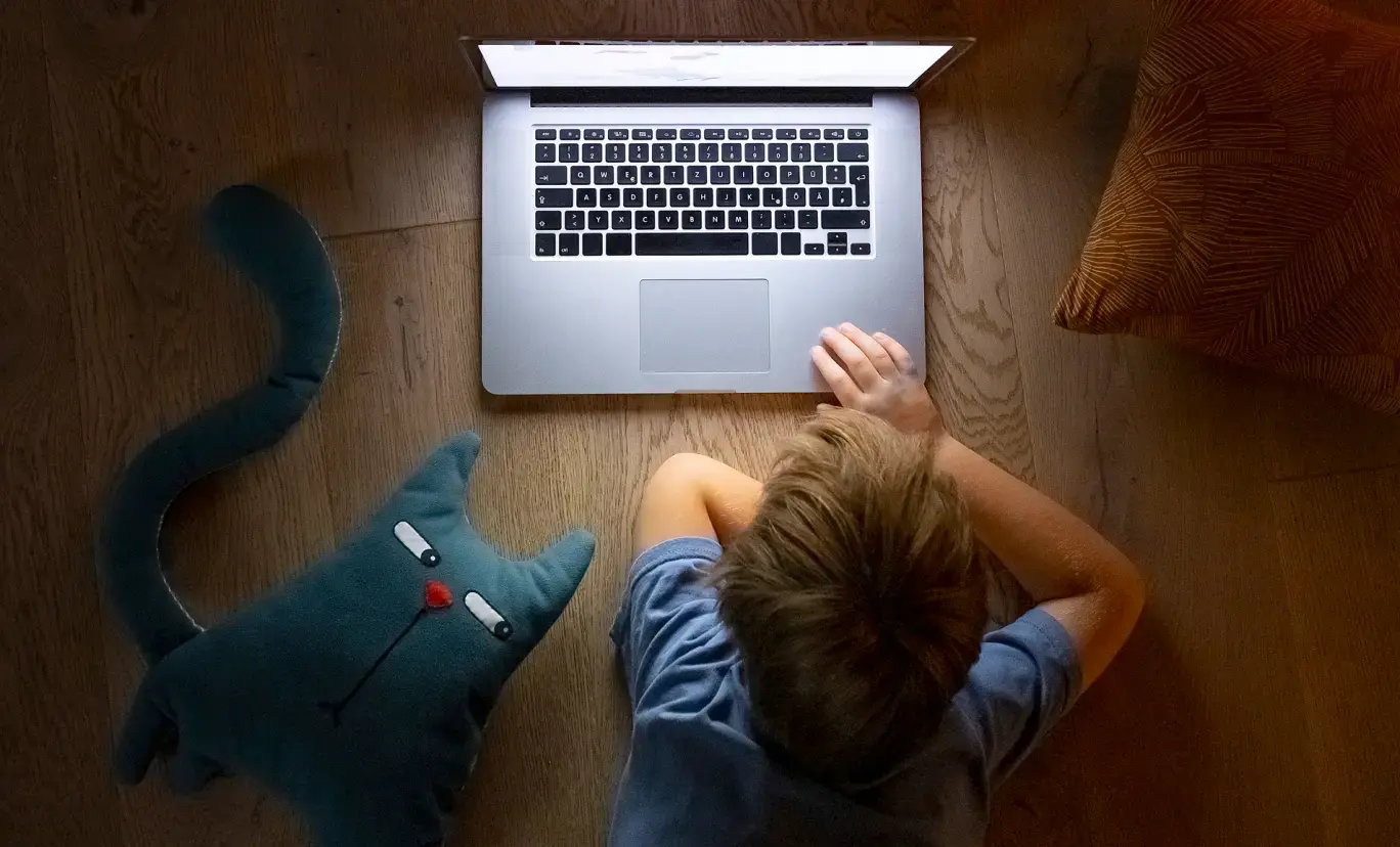 An aerial view of a child using a laptop.