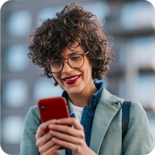 Woman smiling while using her smartphone