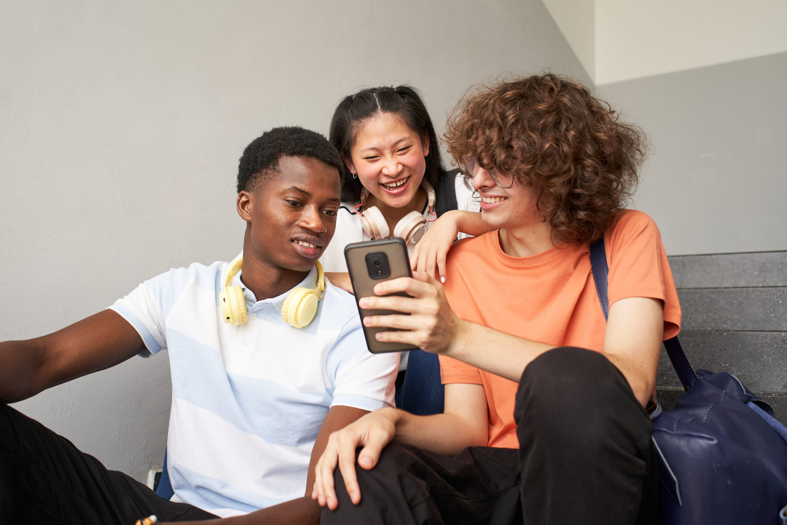 Group of teenagers using their phones safely after completing online age verification