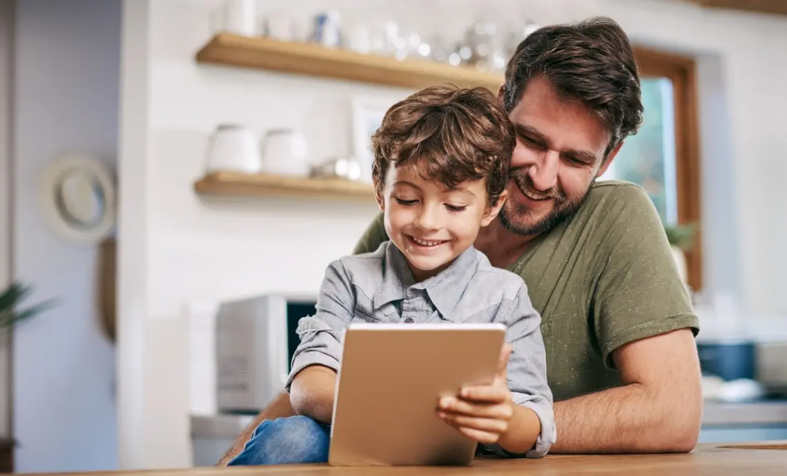Father and young son using iPad together