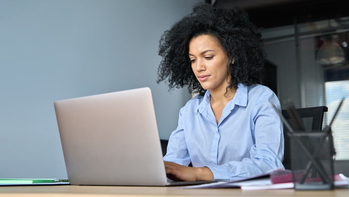 Woman sat at desk looking at laptop