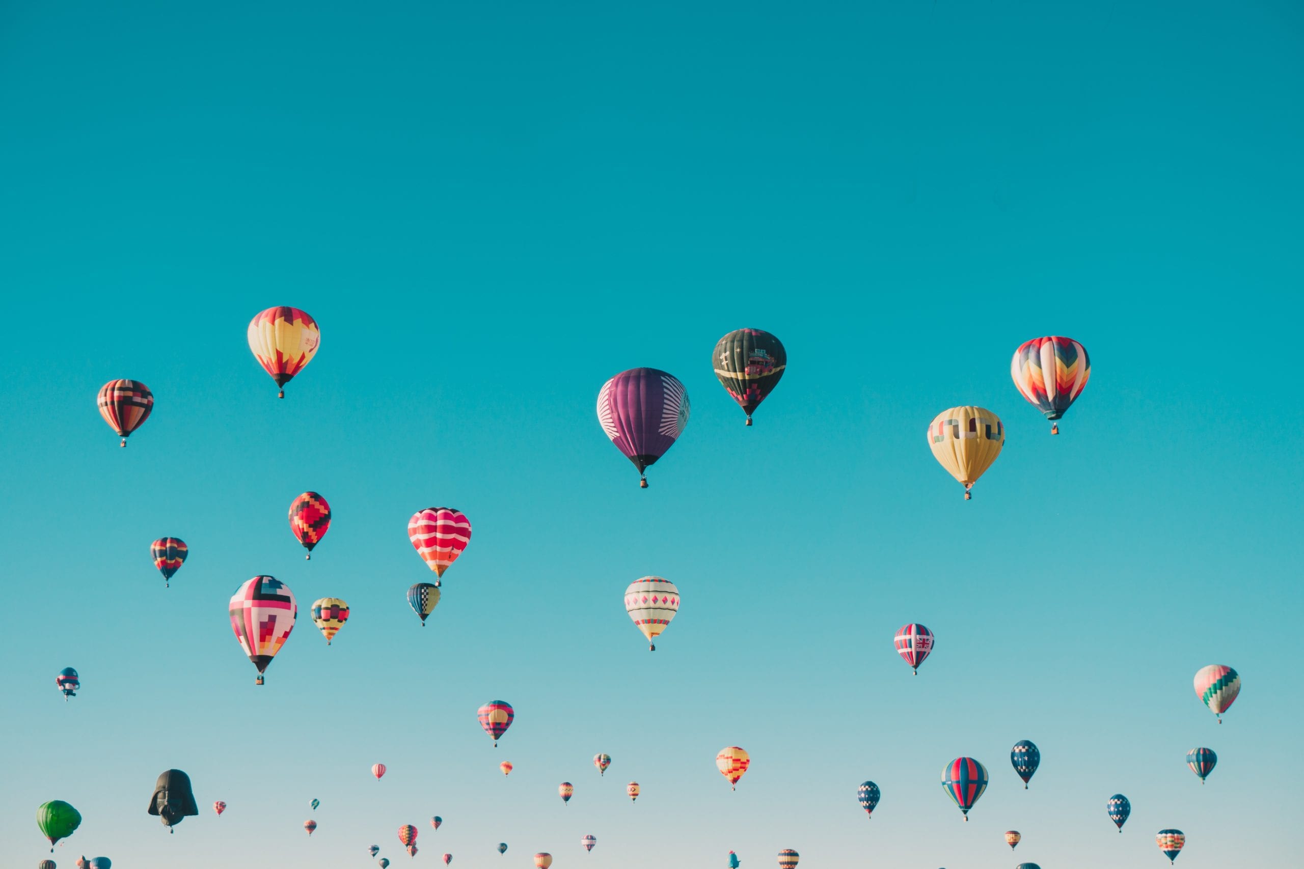 an image of lots of hot air balloons against a deep blue sky