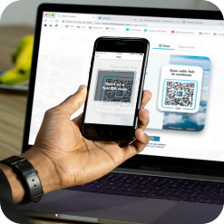 Hand with phone scanning a QR code on a website