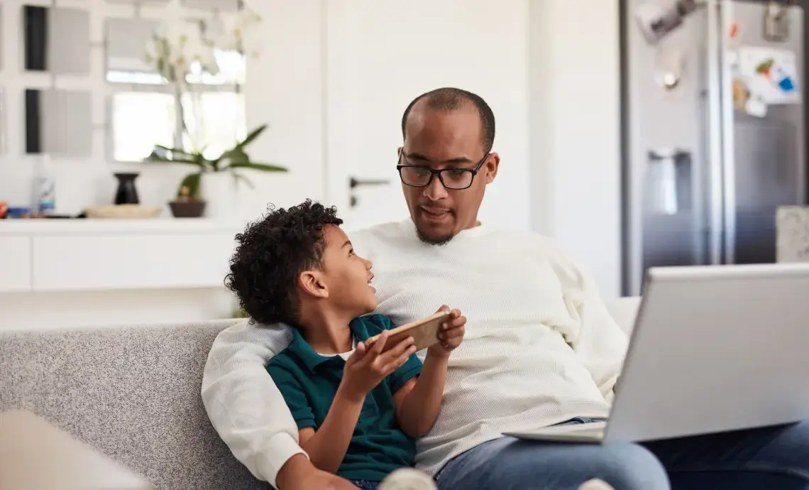 Father and son using devices together