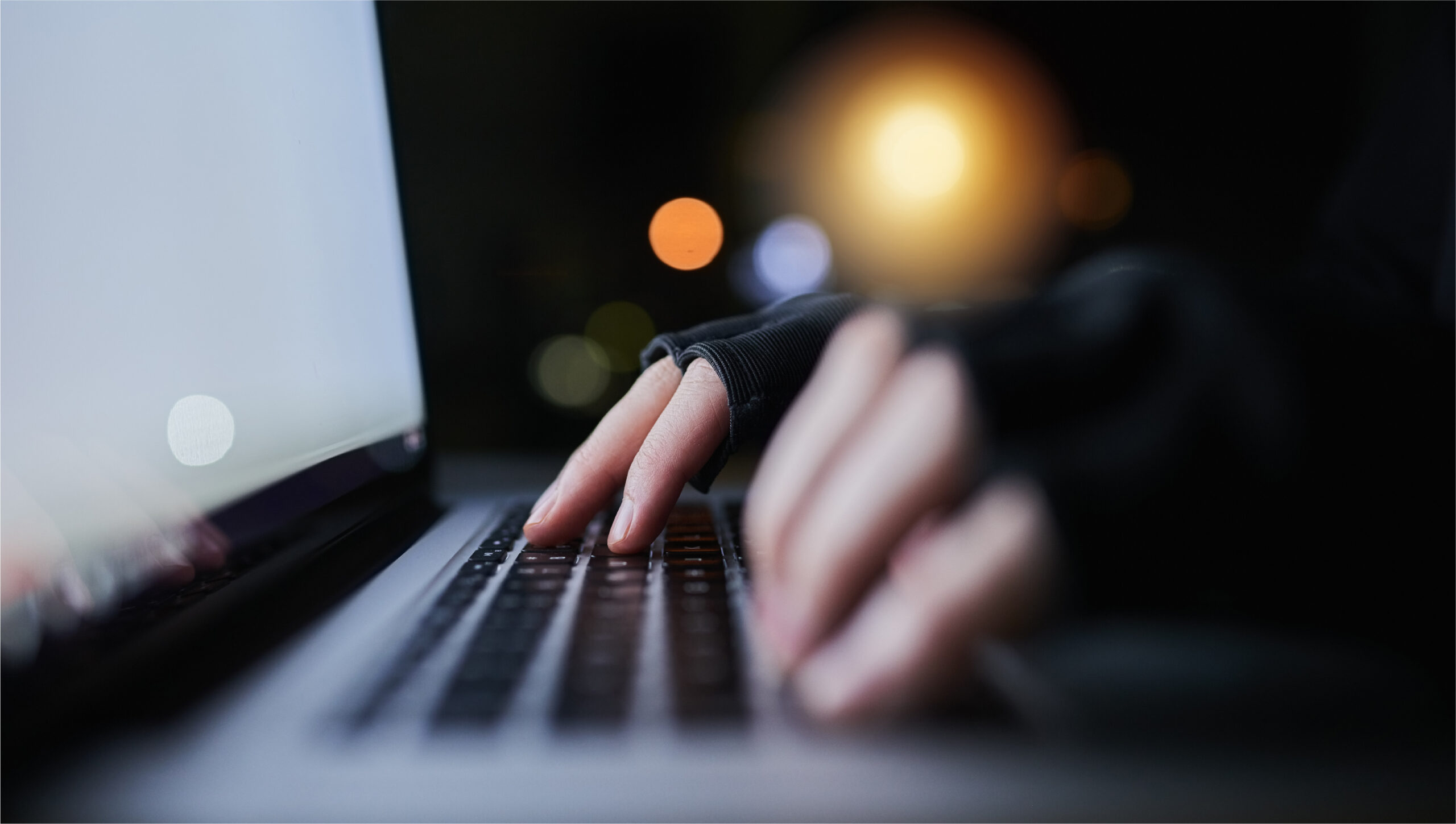 Closeup of fingers typing on laptop keyboard