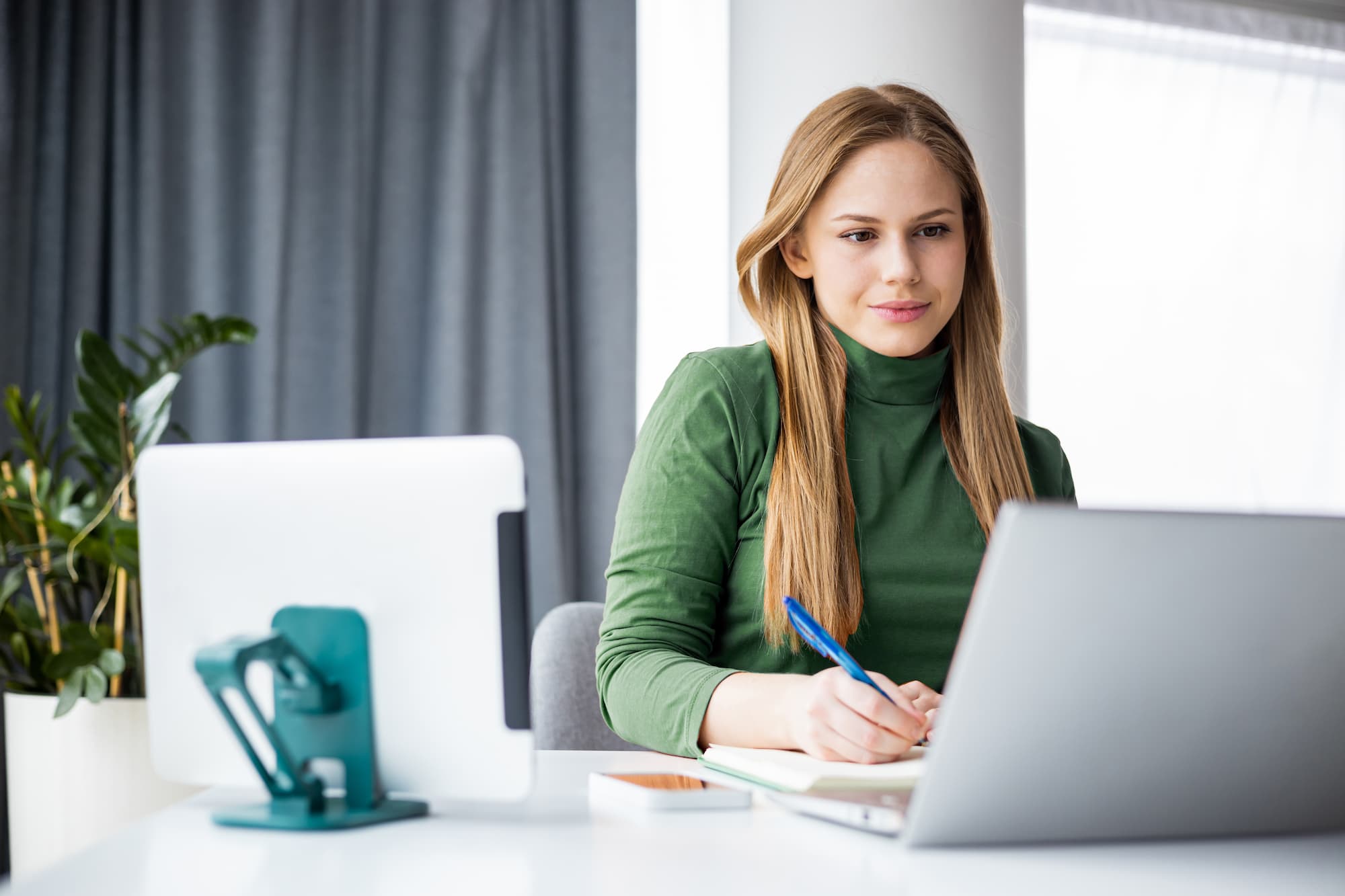 Woman working at desk looking at laptop