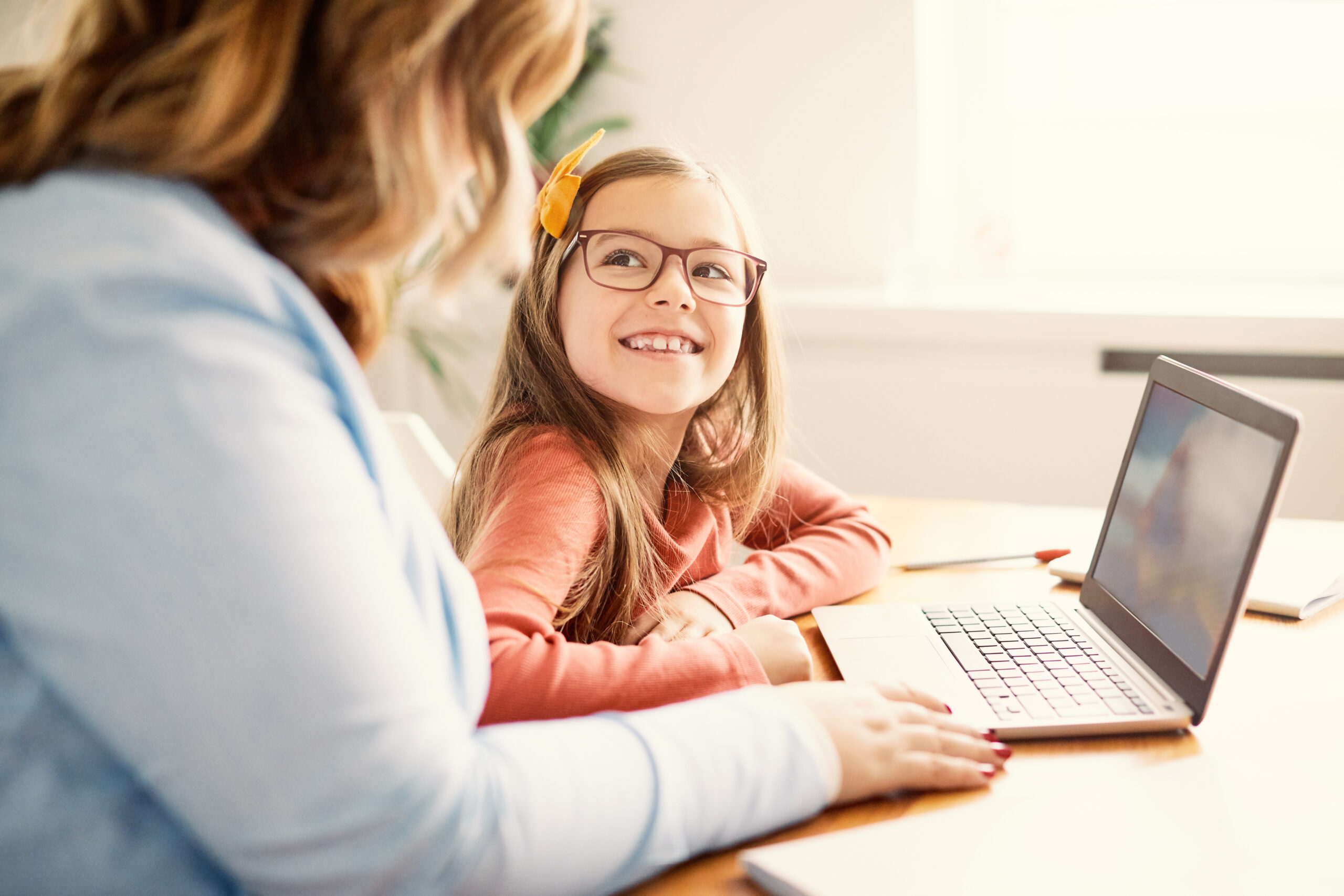 Mother and daughter having fun with laptop at home