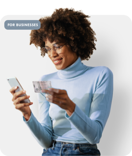 Woman looking at her phone holding a driving license