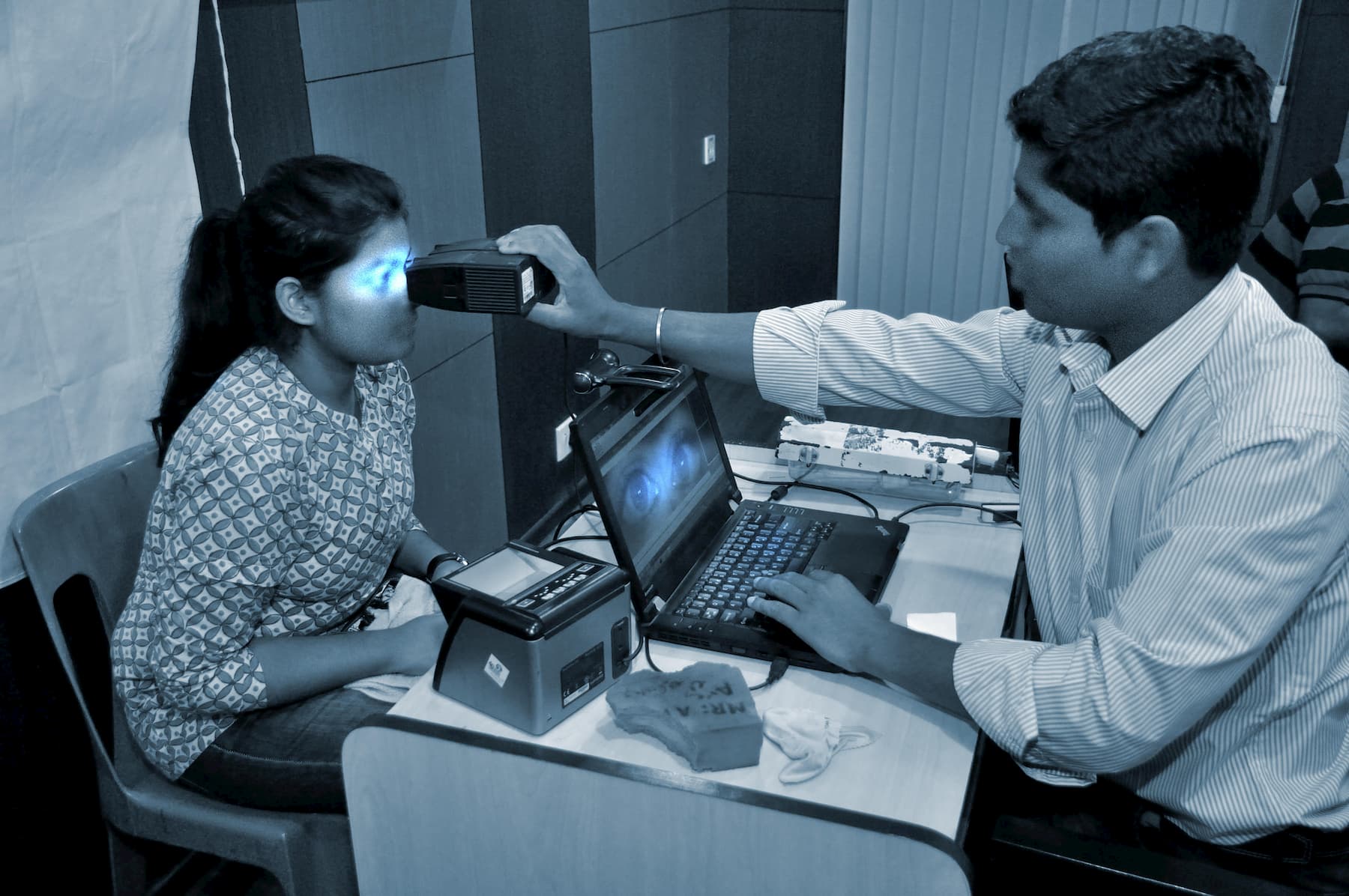 image of a young woman having her eyes scanned a man