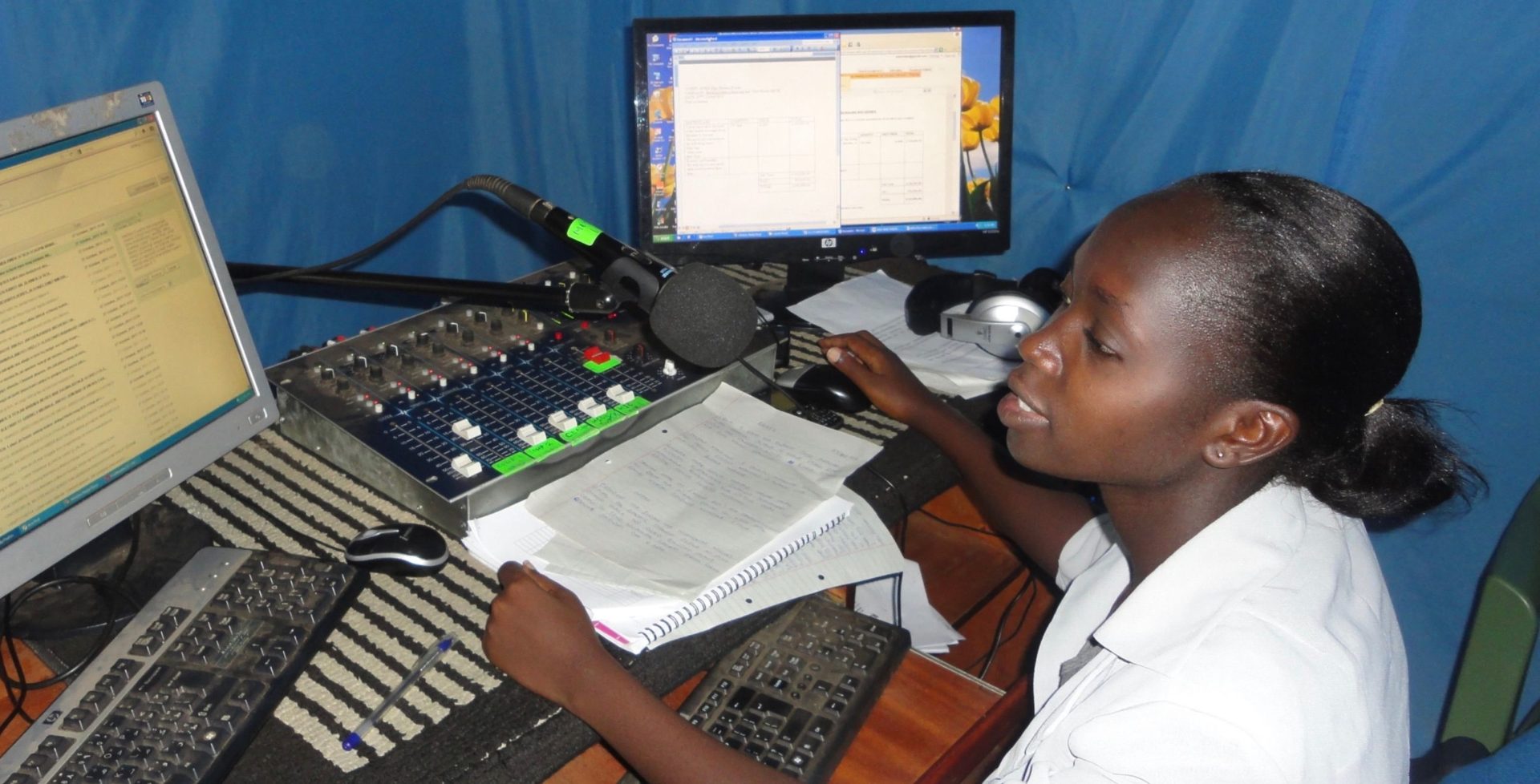 an image of a young girl in front of a computer. she is creating a podcast.