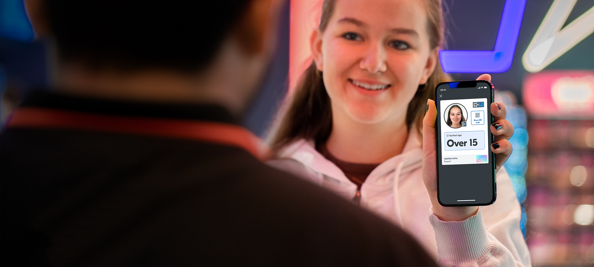 Teenage girl in Cinema showing her reusable verified "over 15" age attribute in her Yoti ID without sharing unnecessary personal details such as name or date of birth.