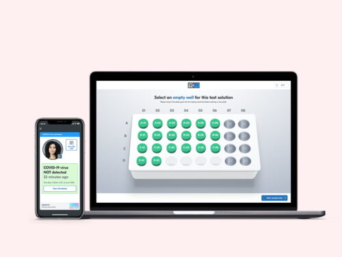 Health testing wells on a laptop and a digital certificate for a patient on an iPhone showing that their test resutls are negative