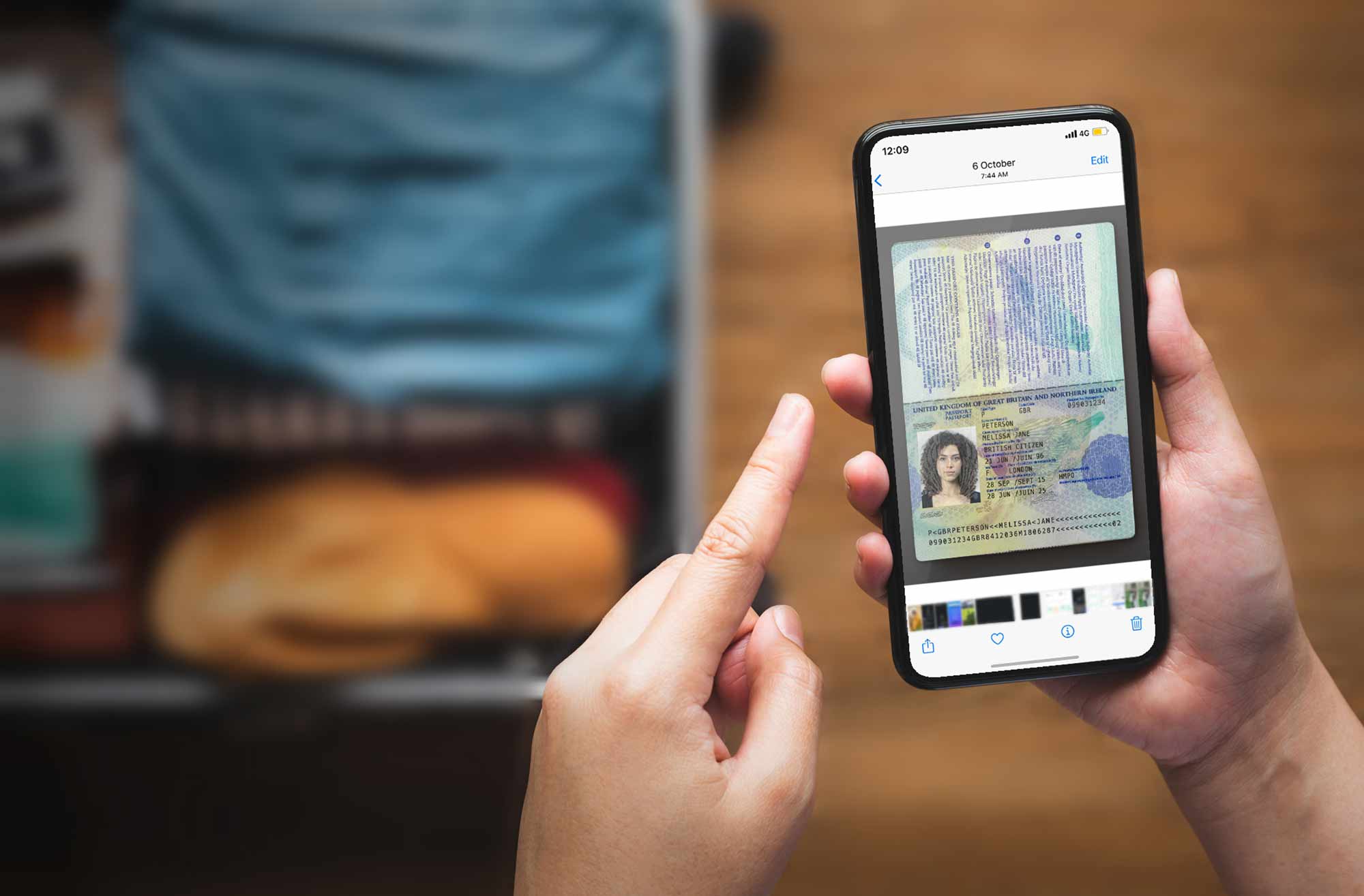 Person looking at photograph of their passport stored as a photo in their iphone photo library