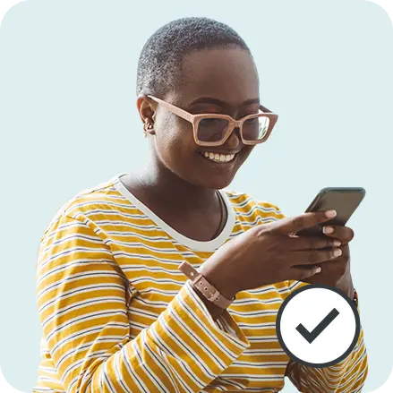 Woman smiling at smartphone with a tick suggesting she has passed her right to rent checks with Yoti